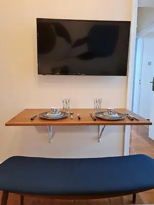 a table with plates and a television on a wall at Georgia on my mind in Athens
