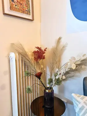 a vase with flowers on a table next to a radiator at Georgia on my mind in Athens