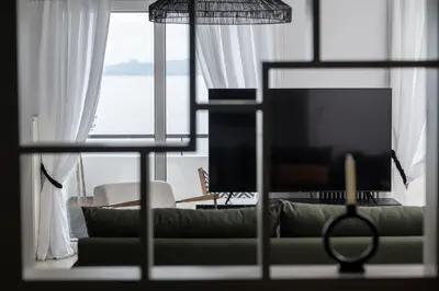 a living room with a couch and a large window at Blue Chill Paradise Seaview Suite w/ Kingbed in Piraeus