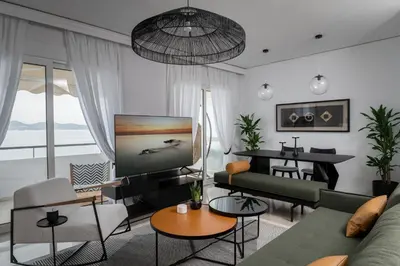 a living room with a couch and a tv at Blue Chill Paradise Seaview Suite w/ Kingbed in Piraeus