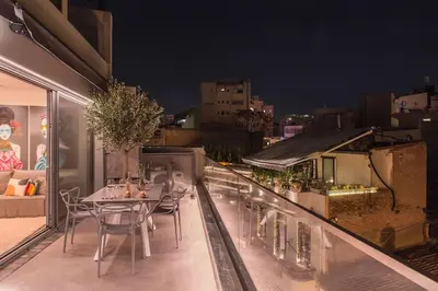 a table and chairs on a balcony at night at Luxury Acropolis View Apartment-Living Stone Black Pearl in Athens