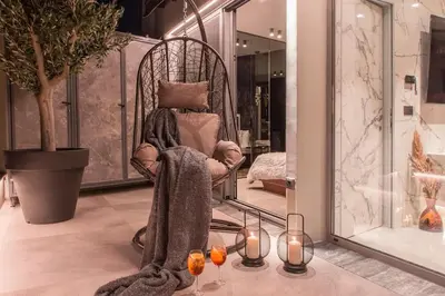 a woman sitting in a chair with a blanket at Luxury Acropolis View Apartment-Living Stone Black Pearl in Athens