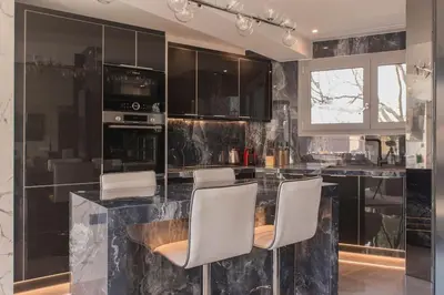 a kitchen with black cabinets and white chairs at Luxury Acropolis View Apartment-Living Stone Black Pearl in Athens