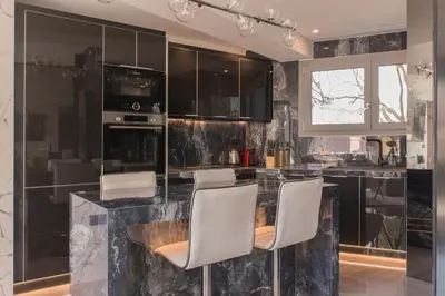 a kitchen with black marble counter and white chairs at Luxury Acropolis View Apartment-Living Stone Black Pearl in Athens