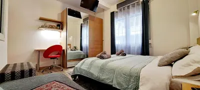a bedroom with a bed with a red chair and a window at Thissio Central Onar in Athens