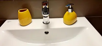a bathroom sink with two yellow objects on it at Thissio Central Onar in Athens