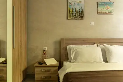 a bedroom with a bed with white sheets and a night stand at Cute full apt w/backyard in Paleo Faliro in Athens