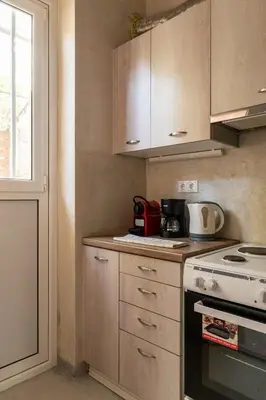 a kitchen with wooden cabinets and a stove at Cute full apt w/backyard in Paleo Faliro in Athens