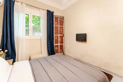 a bedroom with a bed and a tv on the wall at Cute full apt w/backyard in Paleo Faliro in Athens