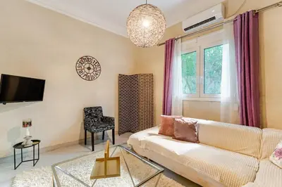 a living room with a white couch and a window at Cute full apt w/backyard in Paleo Faliro in Athens