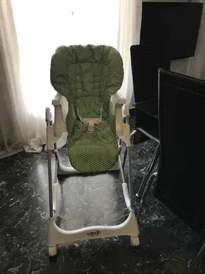 a green and white chair sitting in a room at Cute full apt w/backyard in Paleo Faliro in Athens