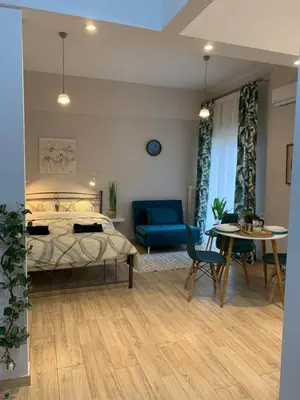 a bedroom with a bed and a table and a couch at Marina Alkamenous apartment in Athens