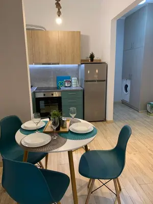 a kitchen with a table and two chairs and a kitchen with a table and chairs at Marina Alkamenous apartment in Athens