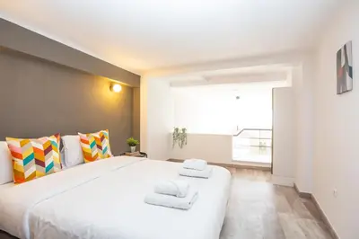 a large white bed in a room with a large window at Psirri Lofts in Athens