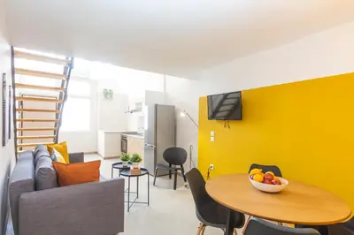 a living room with a table and a yellow wall at Psirri Lofts in Athens