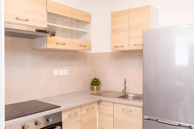 a kitchen with wooden cabinets and a stainless steel refrigerator at Psirri Lofts in Athens