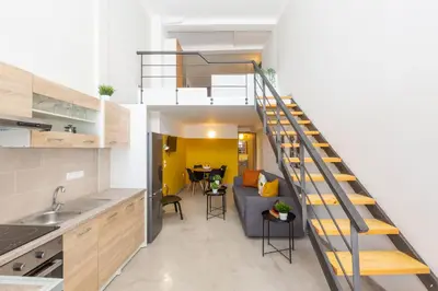 a kitchen and a living room with a spiral staircase at Psirri Lofts in Athens