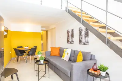 a living room with a couch and a staircase at Psirri Lofts in Athens
