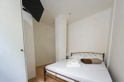 a bedroom with a bed with white sheets and towels at ATHENS COMMERCIAL in Athens