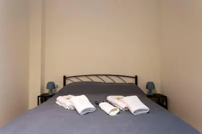 a bed with two white towels on it at ATHENS COMMERCIAL in Athens