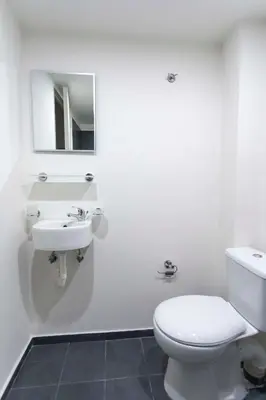 a white bathroom with a toilet and a sink at ATHENS COMMERCIAL in Athens