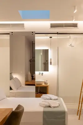 a bedroom with a bed and a mirror at Ciel Suites Athens in Athens