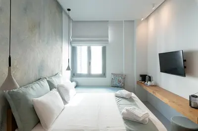 a living room with a couch and a tv at Ciel Suites Athens in Athens
