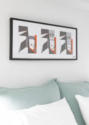 a picture hanging on a wall above a bed at Ciel Suites Athens in Athens