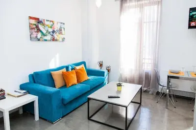 a living room with a blue couch and a table at Aθens Dome - Apartments by Live&Travel in Athens