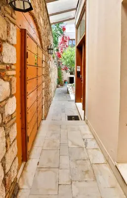 an empty alley with a stone wall and a building at Aθens Dome - Apartments by Live&Travel in Athens