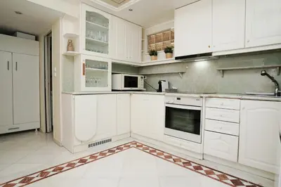 a white kitchen with white cabinets and appliances at Endless Blue Studio in Glyfada in Athens
