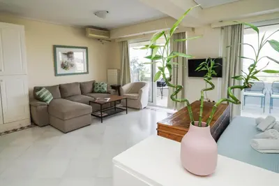a living room with a couch and a vase with a plant at Endless Blue Studio in Glyfada in Athens