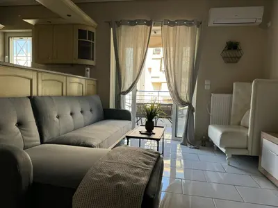 a living room with a couch and a table at AIOLOS LUXURY alimos quiet SUITE 1 in Athens