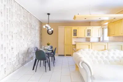 a living room with a white couch and a table at AIOLOS LUXURY alimos quiet SUITE 1 in Athens