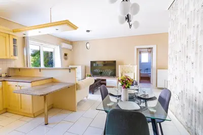 a kitchen and living room with a table and chairs at AIOLOS LUXURY alimos quiet SUITE 1 in Athens