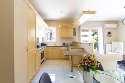 a kitchen with yellow cabinets and a table at AIOLOS LUXURY alimos quiet SUITE 1 in Athens