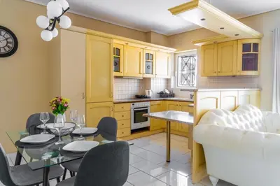 a kitchen and dining room with a table and chairs at AIOLOS LUXURY alimos quiet SUITE 1 in Athens