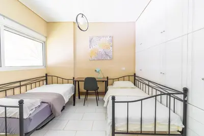 two beds in a room with a desk and a chair at AIOLOS LUXURY alimos quiet SUITE 1 in Athens