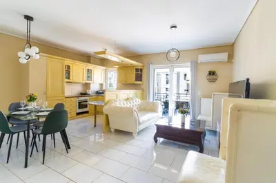 a kitchen and living room with a couch and a table at AIOLOS LUXURY alimos quiet SUITE 1 in Athens