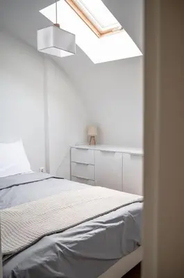 a white bedroom with a bed and a skylight at Μεζονέτα με θέα στο πάρκο Σταύρος Νιάρχος TWO in Athens
