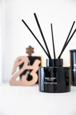 a black bottle of reichen herzymes next to a candle at Μεζονέτα με θέα στο πάρκο Σταύρος Νιάρχος TWO in Athens