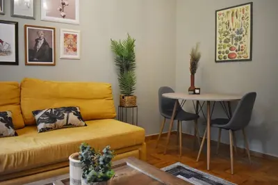 a living room with a yellow couch and a table at Vintage Apartment in Athens