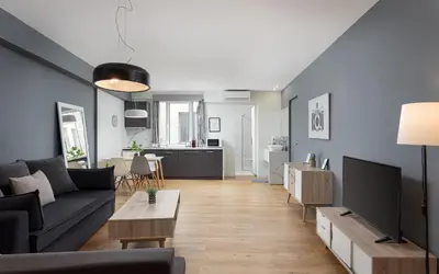 a living room with a couch and a tv at Comfort Suite by Acropolis Cozy Suites in Athens