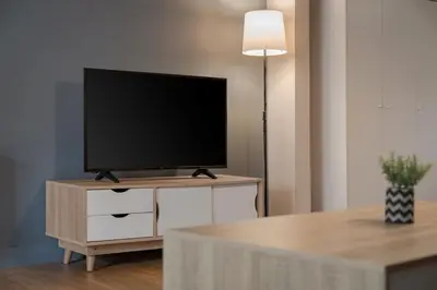 a flat screen tv sitting on top of a dresser at Comfort Suite by Acropolis Cozy Suites in Athens