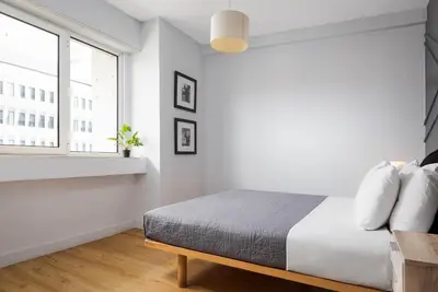 a white bedroom with a bed and a window at Standard Suite by Acropolis Cozy Suites in Athens