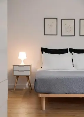 a bedroom with a bed and a nightstand with a lamp at Deluxe Suite by Acropolis Cozy Suites in Athens