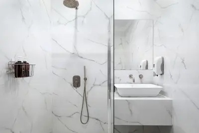a white bathroom with a shower and a sink at Superior Suite by Acropolis Cozy Suites in Athens