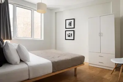 a white bedroom with a bed and a window at Superior Suite by Acropolis Cozy Suites in Athens