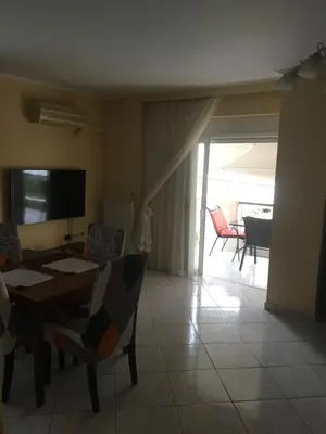 a living room with a table and chairs and a television at SECOND FLOOR Best stay in Athens