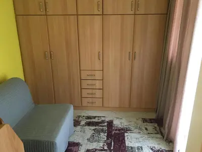 a bedroom with wooden cabinets and a chair and a rug at SECOND FLOOR Best stay in Athens